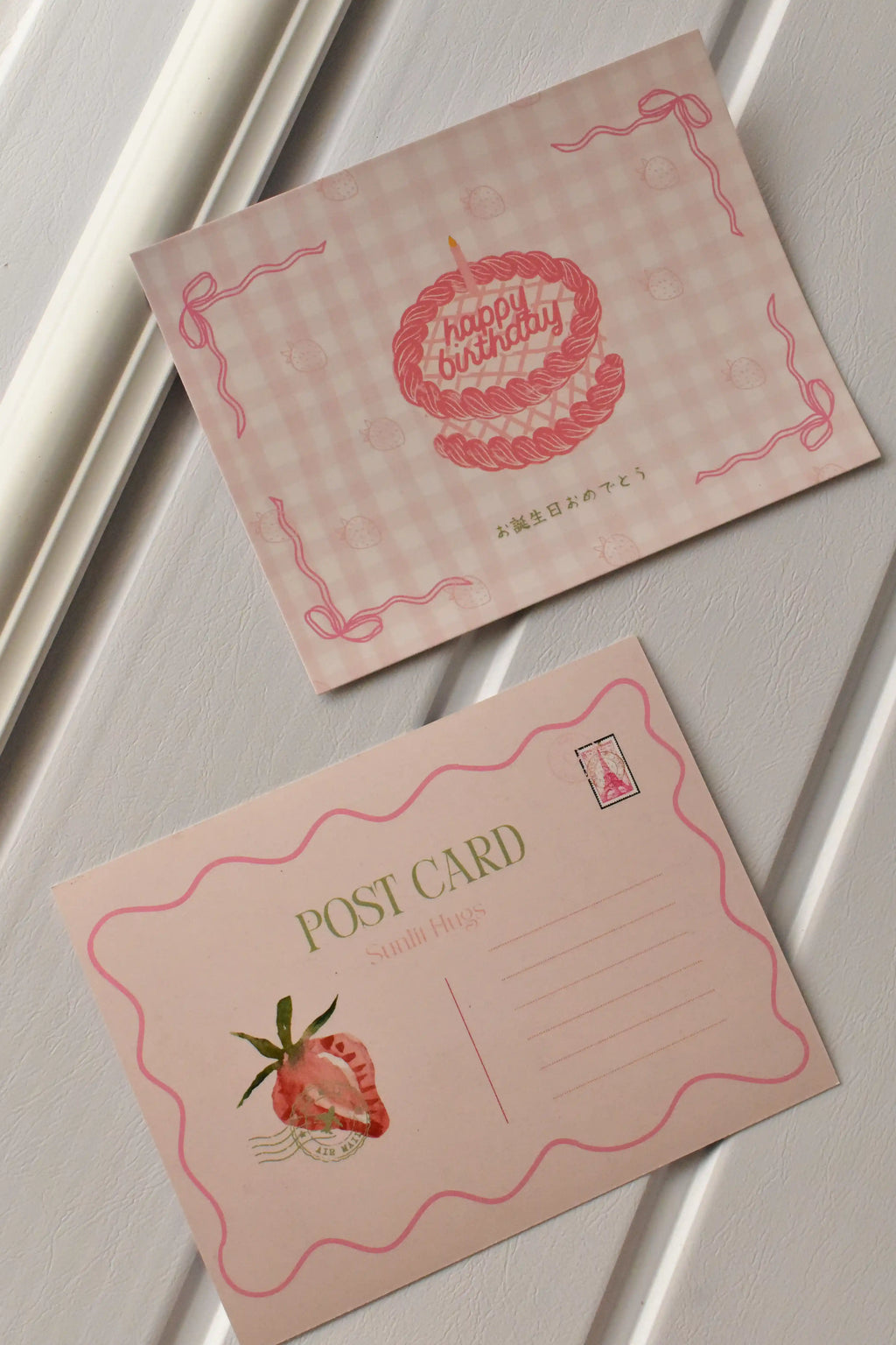 This image displays both sides of the postcard, highlighting the pink gingham cake design on the front and the strawberry postcard template on the reverse, ready for sending happy mail.
