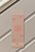 This image shows a close-up of the Cake Bookmark front, highlighting the charming pastel pink colour and sweet strawberry cake design with a delicate lace border.