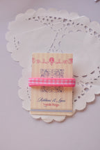 Narrow pink and white gingham ribbon (2 Metres) wrapped around a "Sunlit Hugs" card, with a loose strand flowing below on a lace doily.
