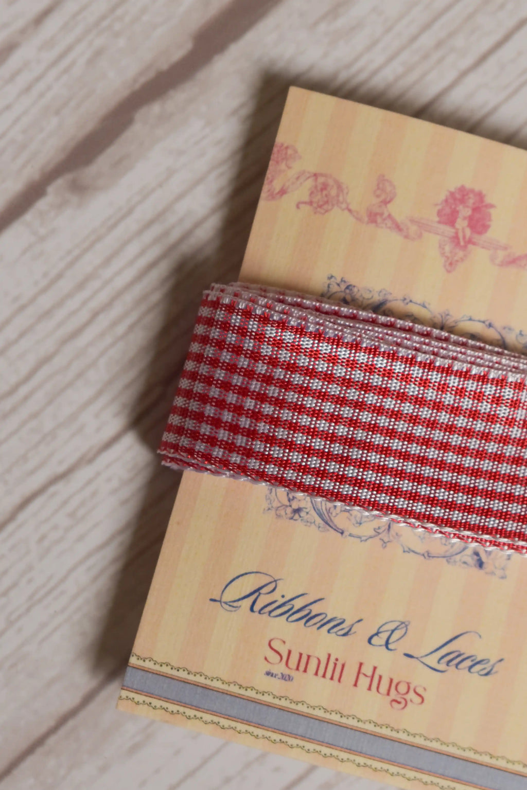 Close-up of Strawberry Jam Ribbon displayed on a Sunlit Hugs ribbon card, highlighting its strawberry red and white checked pattern.