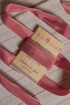 Strawberry Jam Ribbon shown with loose red and white checked ribbon strands around the product card, suitable for crafts, packaging, scrapbooking, bows, and gift styling.