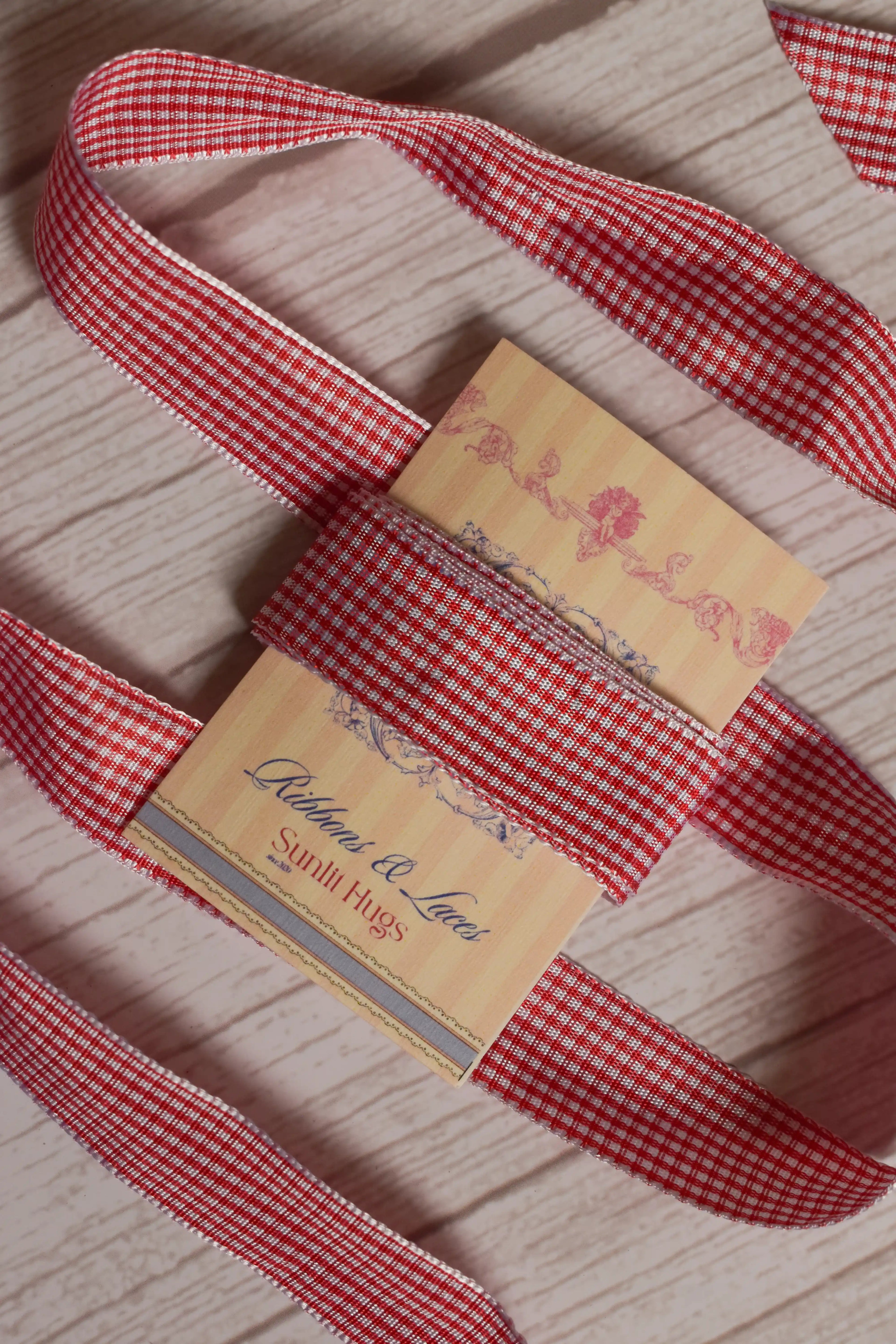 Strawberry Jam Ribbon shown with loose red and white checked ribbon strands around the product card, suitable for crafts, packaging, scrapbooking, bows, and gift styling.