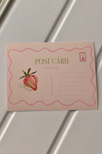This clear view shows the back of the postcard, highlighting the pink strawberry illustration and the lines for the address and message, ready for a thoughtful, handwritten note.