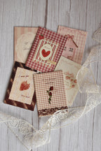 Angled view of the Sunlit Hugs Set of 6 Love Series Cards bundle showcasing various romantic greetings including "To my forever valentine" and "I miss you berry much" alongside delicate white floral lace.
