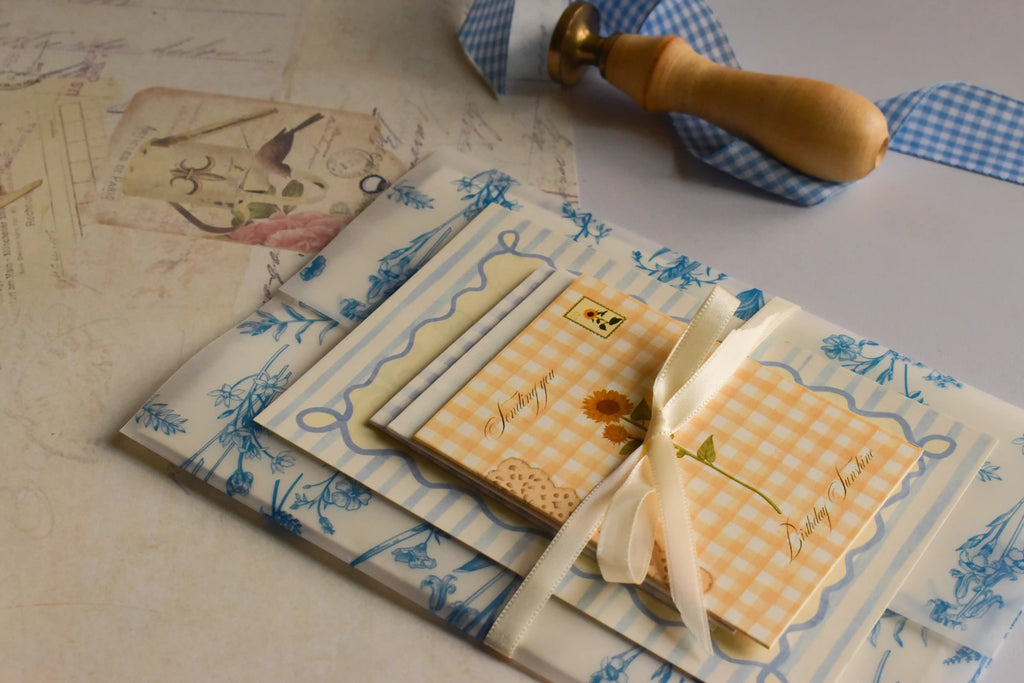 The Birthday Sunshine Keepsake Bundle displayed with coordinating blue floral paper, cream ribbon, and charming paper keepsakes designed for meaningful gifting.