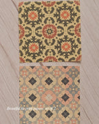 Two decorative paper sheets with geometric floral pattern on a wooden surface