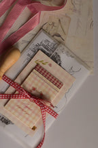 A detailed flat lay displaying the contents of the Timeless Love Birthday Bundle, including the Classic Scarlet Letter with wax seal, I Just Called To Say I Love You Postcard, Mi Amor Por Ti Greeting Card and Happiest Birthday To You Mini Greeting Card.
