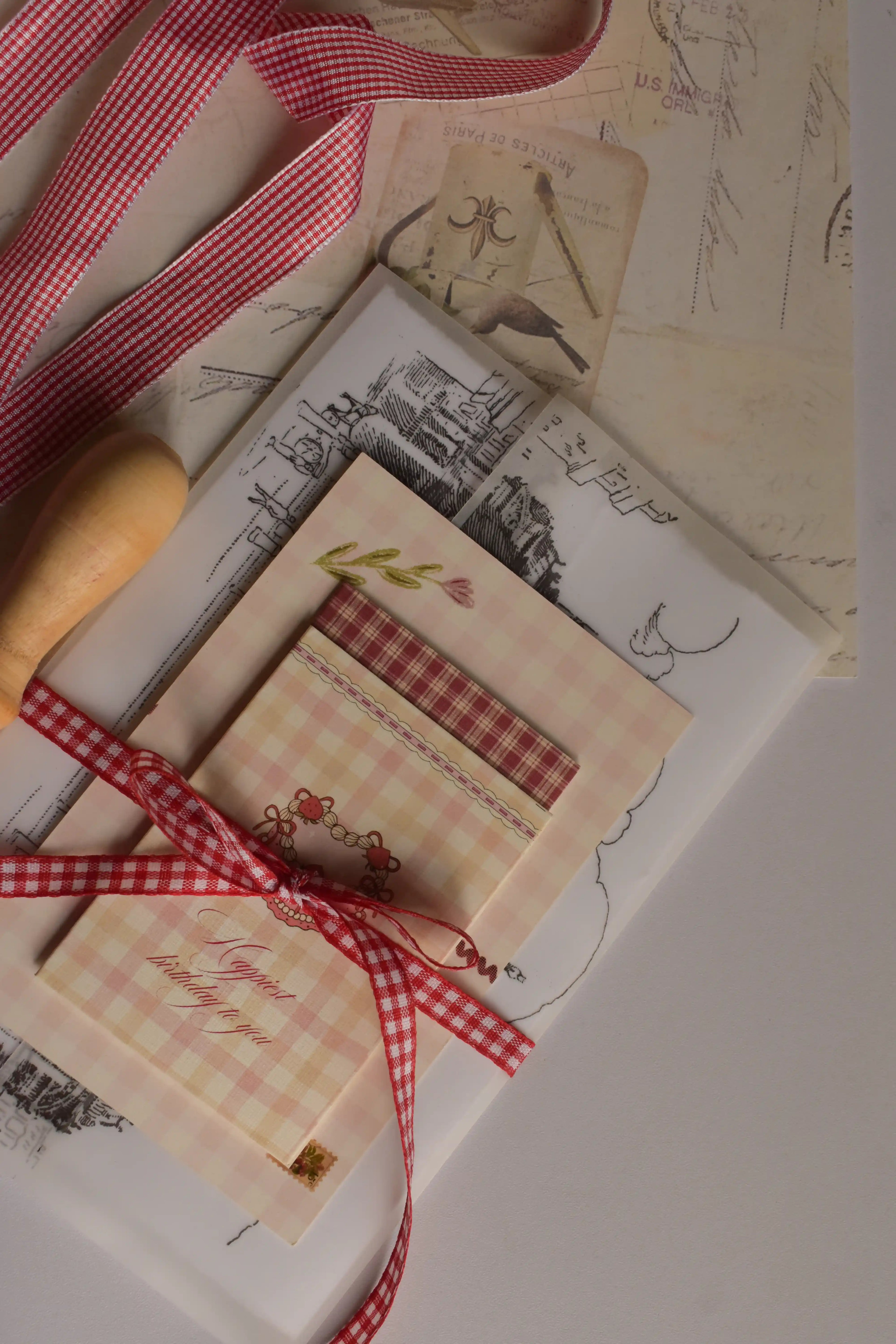A detailed flat lay displaying the contents of the Timeless Love Birthday Bundle, including the Classic Scarlet Letter with wax seal, I Just Called To Say I Love You Postcard, Mi Amor Por Ti Greeting Card and Happiest Birthday To You Mini Greeting Card.