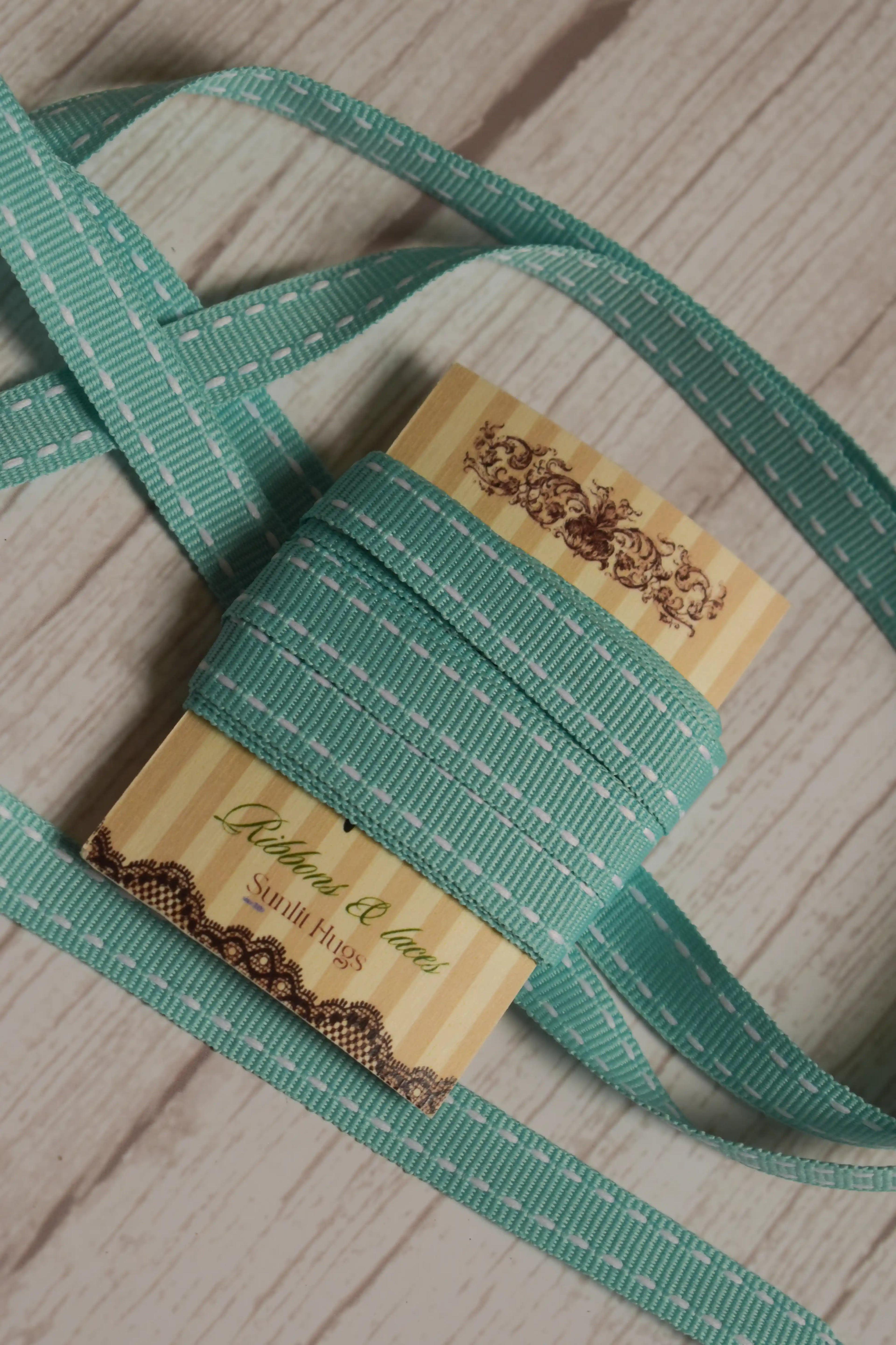 Turquoise stitches Ribbon arranged loosely around the display card, showing its length, stitched pattern, and suitability for gift wrapping, crafts, and decorative packaging.