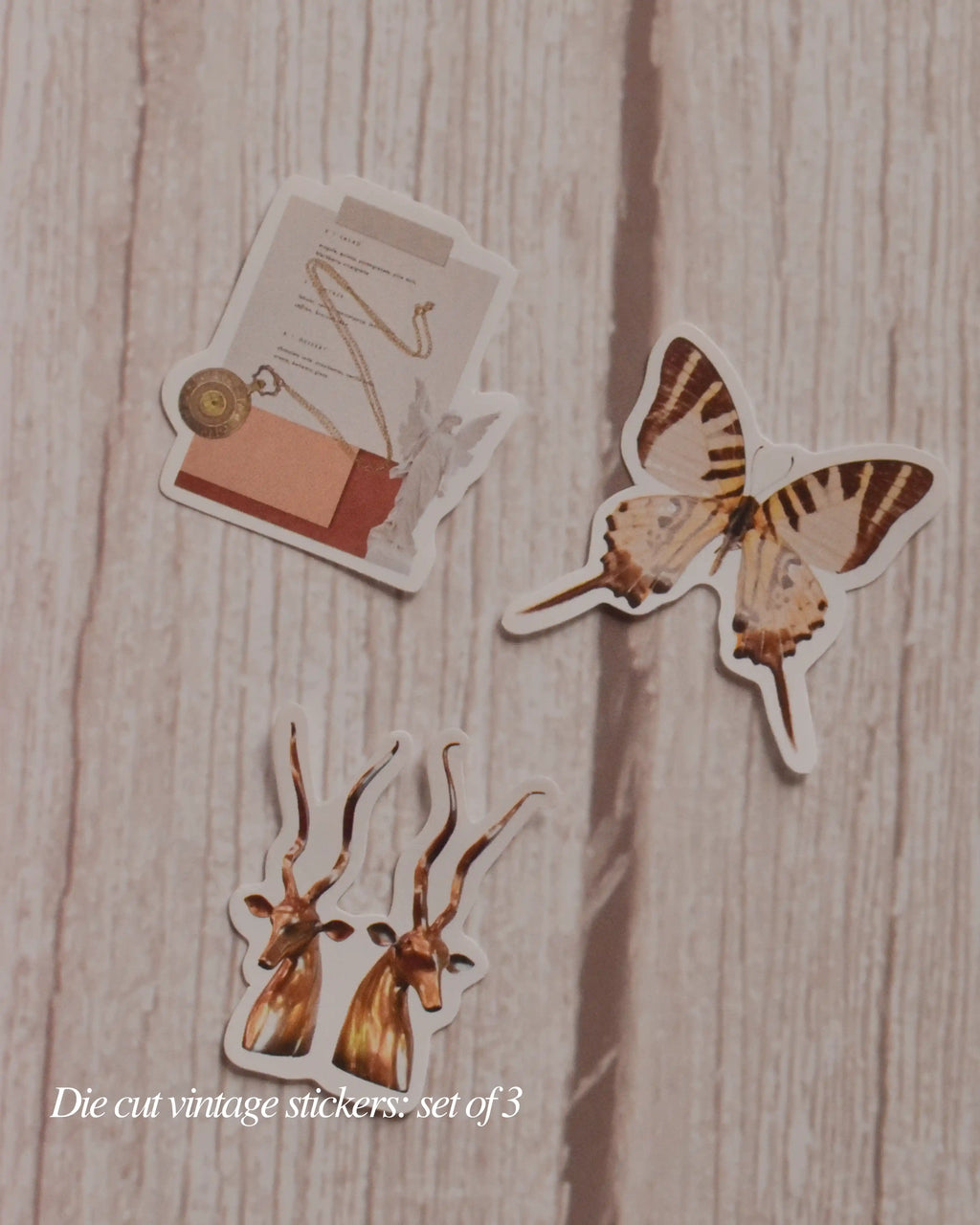 Set of three die-cut vintage-style stickers on a wooden surface
