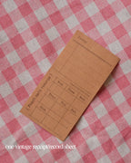 One vintage brown punch card record sheet with lines for recording daily activities and times.