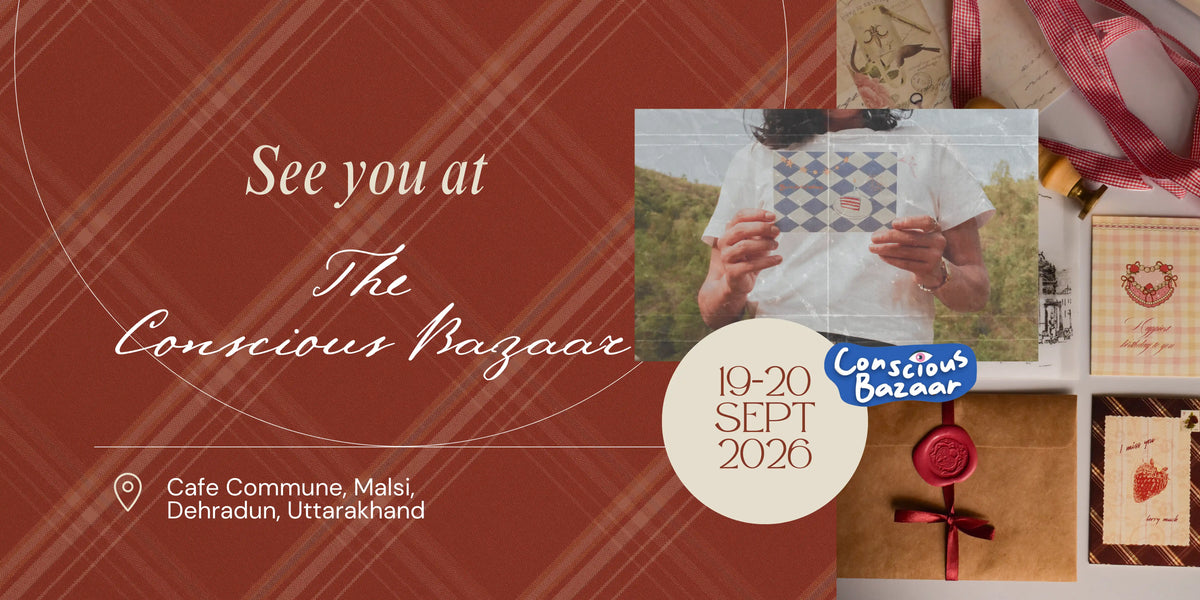 Sunlit Hugs website banner for The Conscious Bazaar, 19-20 September 2026 at Cafe Commune, Malsi, Dehradun, Uttarakhand. A rust red tartan background with a fine sketch swan surrounds a collage of Sunlit Hugs stationery, including hands holding a blue checked birthday postcard, red gingham ribbon, an ivory botanical wax seal on a kraft envelope, a personalised yellow gingham card, and a strawberry postcard reading I miss you very much, with the event logo and date on a cream circle.