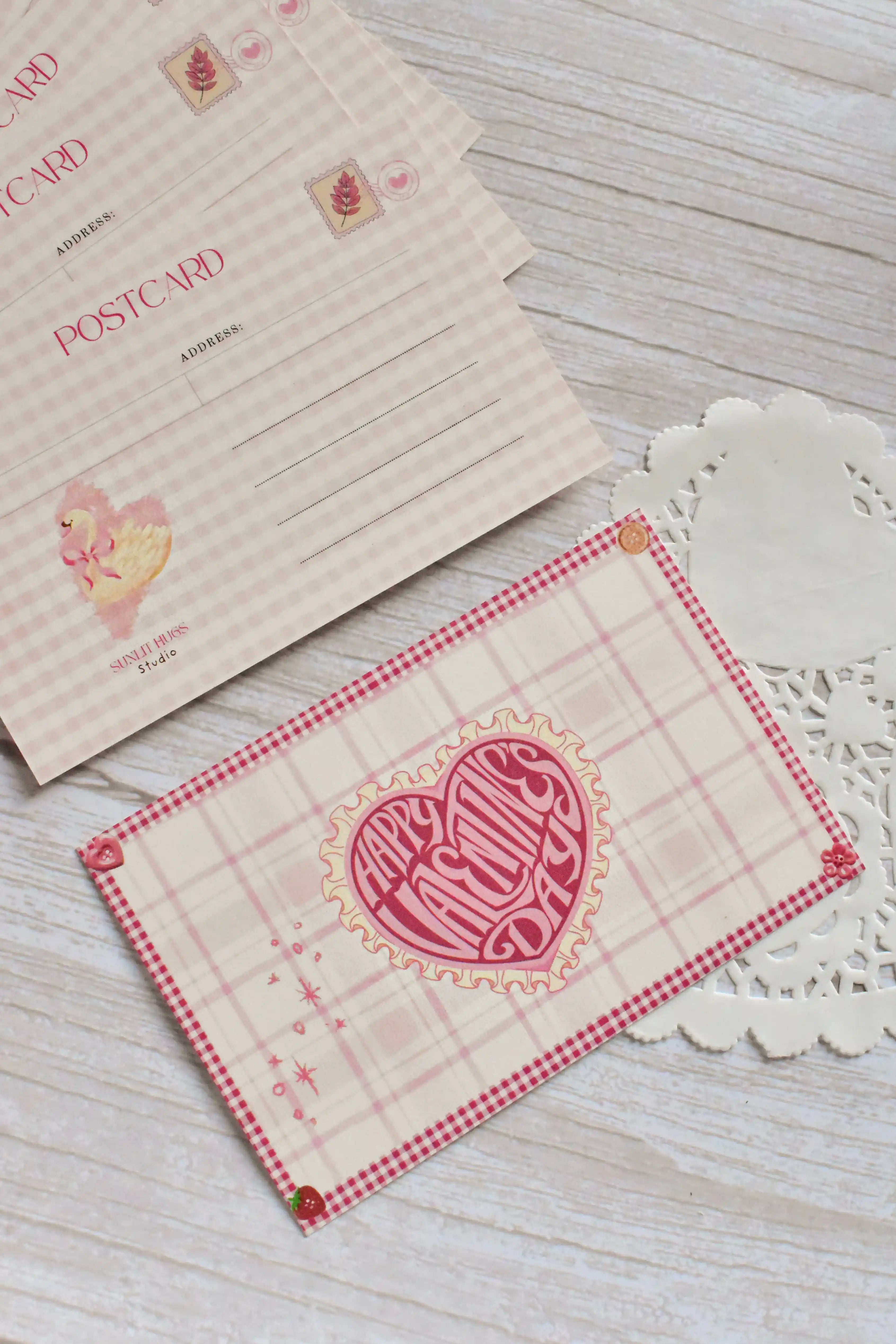 A Happy Valentine's Day postcard is shown with pink gingham styling and retro swan-and-heart artwork.
