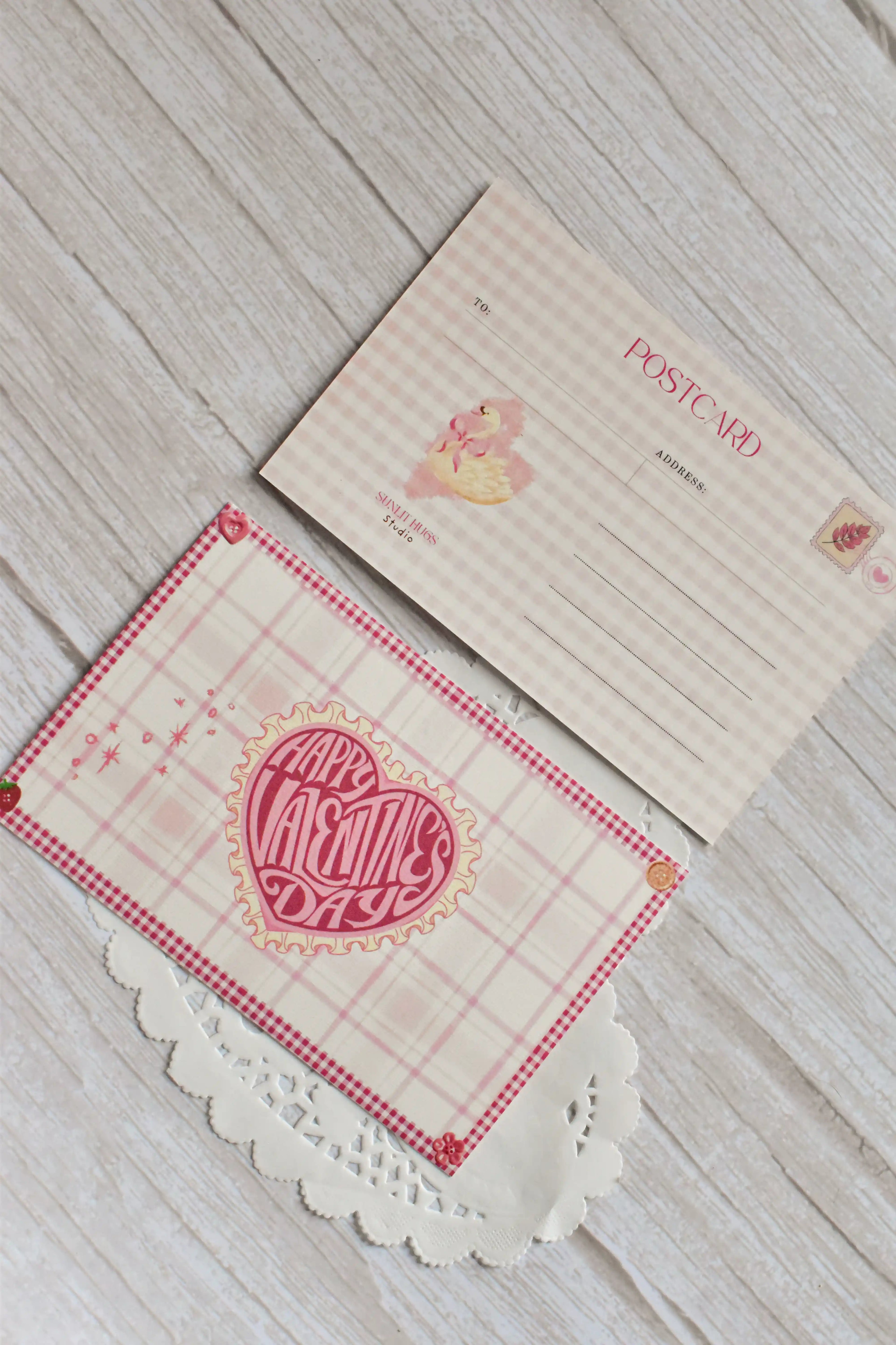 A Happy Valentine's Day postcard is styled in pink gingham with a swan and heart design.