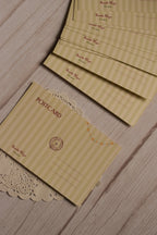 Back design of the birthday postcard displayed with several matching postcard backs, showing the writing area, Sunlit Hugs Studio branding and yellow star garland detail.