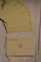 The cream striped back of the birthday postcard displayed alongside multiple yellow rabbit and strawberry postcard fronts.