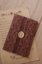 Deep burgundy lace-patterned vellum folded around the Rosie personalised letter and finished at the centre with a creamy ivory botanical wax seal.