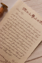 Close-up of the Rosie personalised letter showing its high-quality textured handmade paper, deckled edge, ornate vintage detailing and elegant calligraphy-style message.