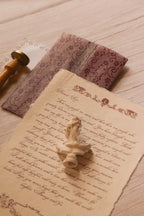 Rosie personalised vintage letter styled on textured handmade paper beside its deep burgundy lace-patterned vellum wrapper and vintage stationery details.