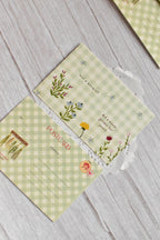 A green gingham garden postcard features cottagecore floral artwork and the phrase Not a Bouquet.