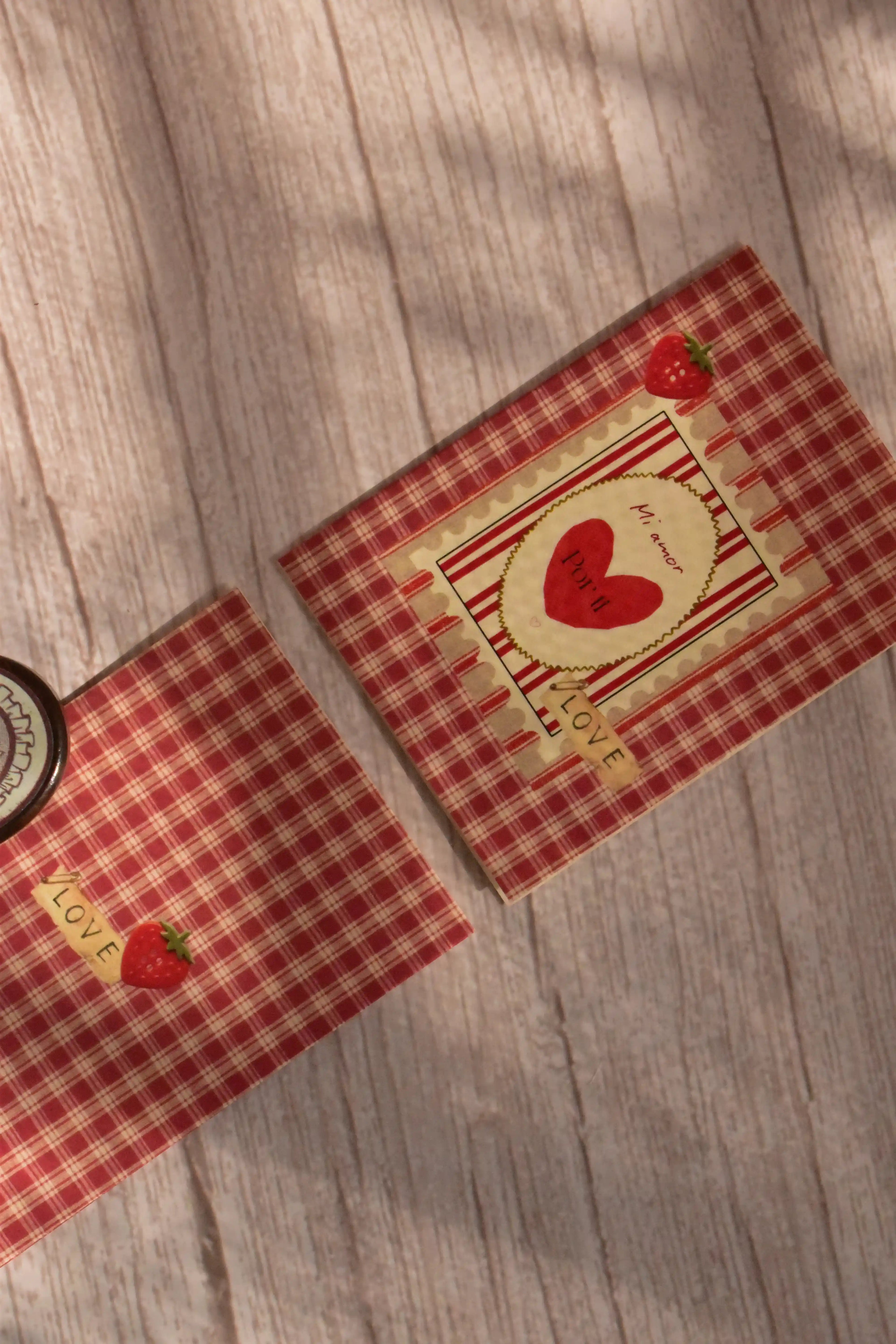 A mini Mi Amor greeting card features red gingham, a strawberry illustration, and a matching pink envelope.