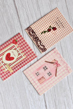 A set of three vintage love mini greeting cards is arranged together with soft pink romantic stationery styling.
