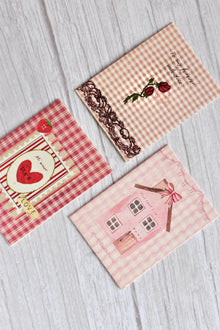 A set of three vintage love mini greeting cards is arranged together with soft pink romantic stationery styling.