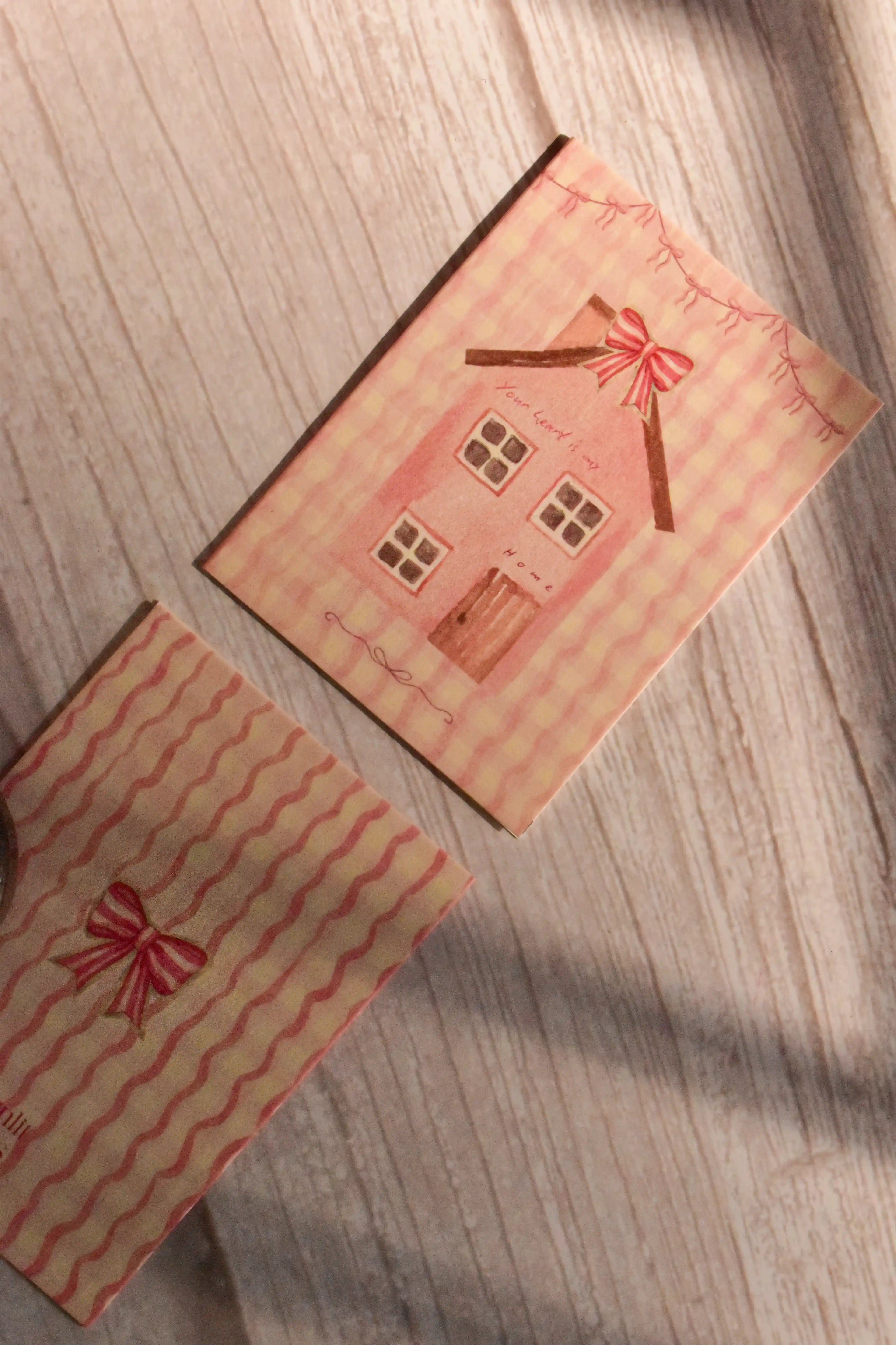 A mini greeting card reads Your Heart is My Home with a pink cottage illustration and bow detail.