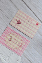 A pink gingham postcard reads You Make My Heart Sing with retro cherries and bow illustrations.