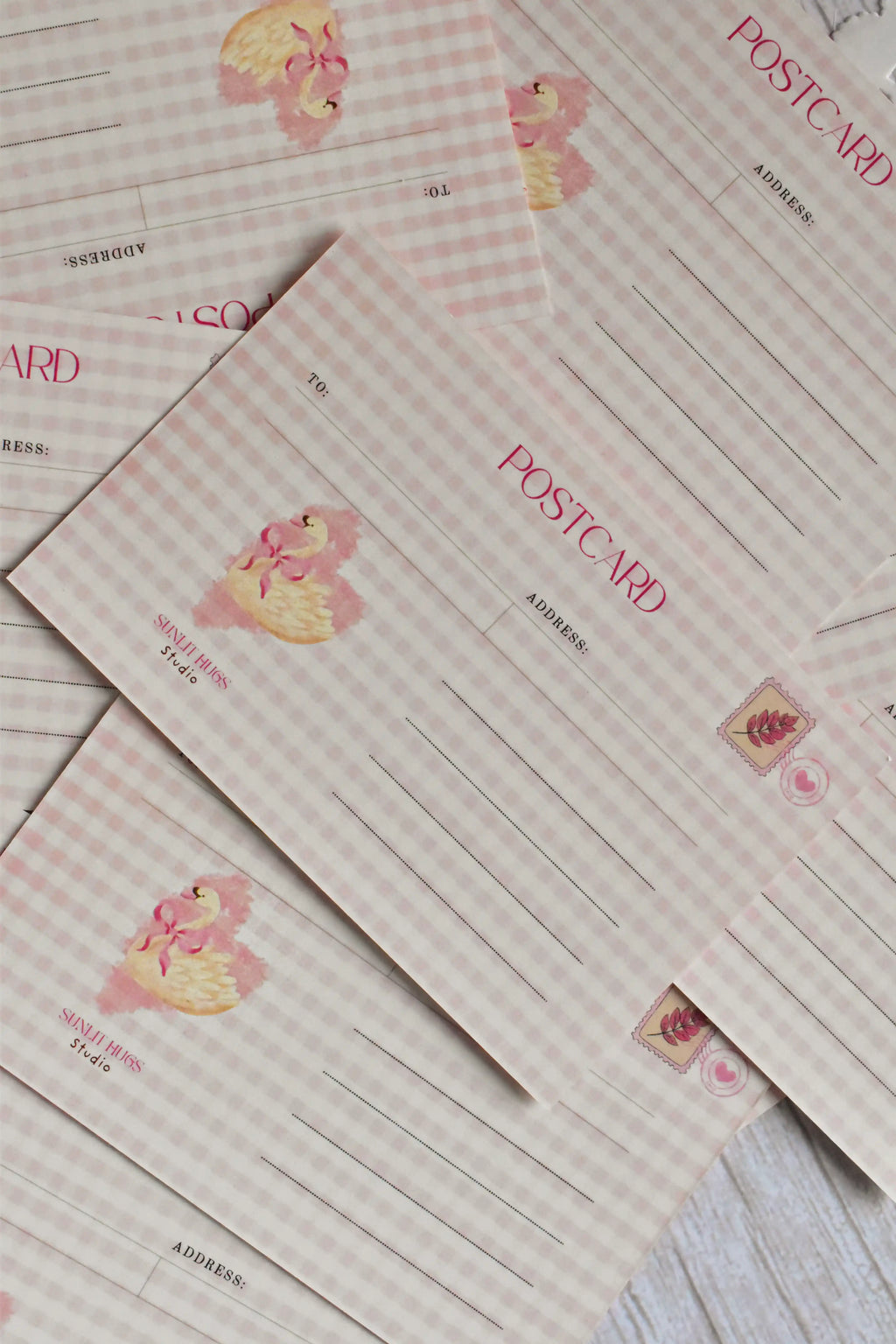 A pink gingham Valentine's postcard features a retro heart and swan illustration on the front.