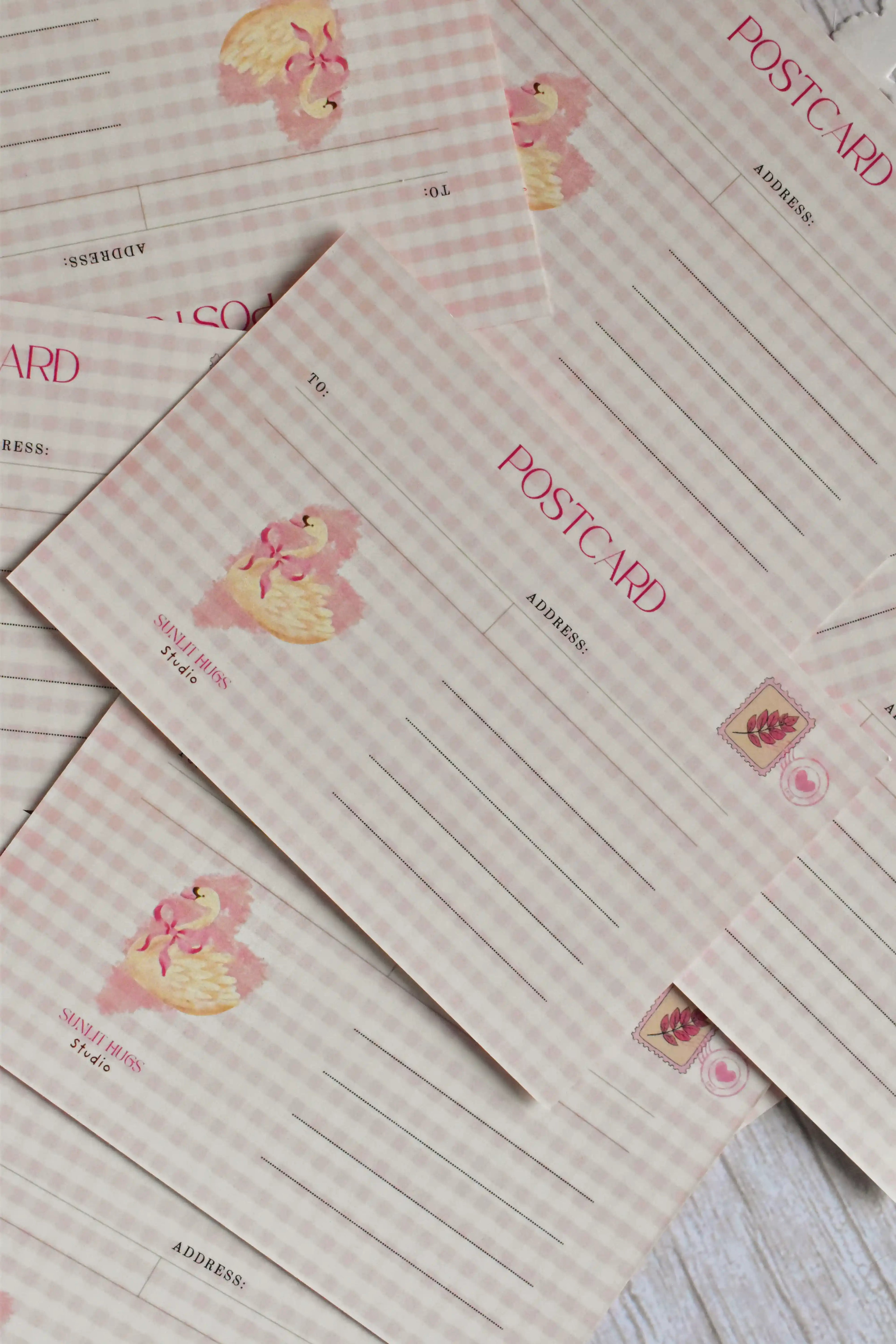 A pink gingham Valentine's postcard features a retro heart and swan illustration on the front.