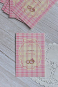 A pink gingham postcard shows retro cherries, bows, and the message You Make My Heart Sing.
